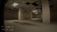 Dark Backrooms hallway with flickering ceiling lights, empty office-like rooms, and a figure lying on the floor in the distance.