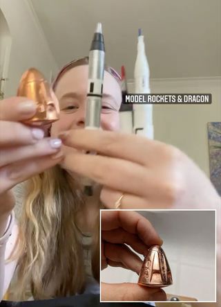 Inspiration4 crew member Hayley Arceneaux holds up models she is taking to space, including a copper-plated pewter miniature of her spacecraft, SpaceX's Crew Dragon capsule, that she found on Etsy.
