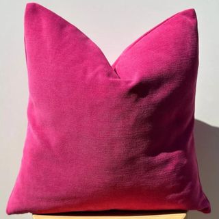 pink throw pillow on a white background