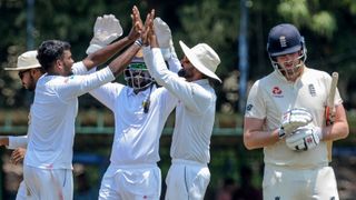 Sri Lanka Board President's XI Ramesh Mendis (2L) celebrates with his teammates after he dismissed England's Dom Sibley (R) during the opening day of a four-day practice match between Sri Lanka Board President's XI and England at the P. Sara Oval Cricket Stadium in Colombo on March 12, 2020.