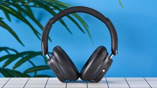 a pair of black baseus bowie 30 max headphones with soft rounded square cups with a blue background