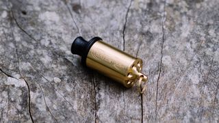 A brass whistle on some wood
