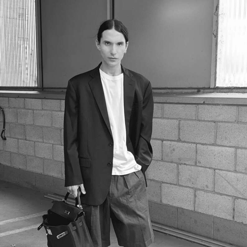 Hairstylist Adrian Arredondo poses for a black-and-white portrait.