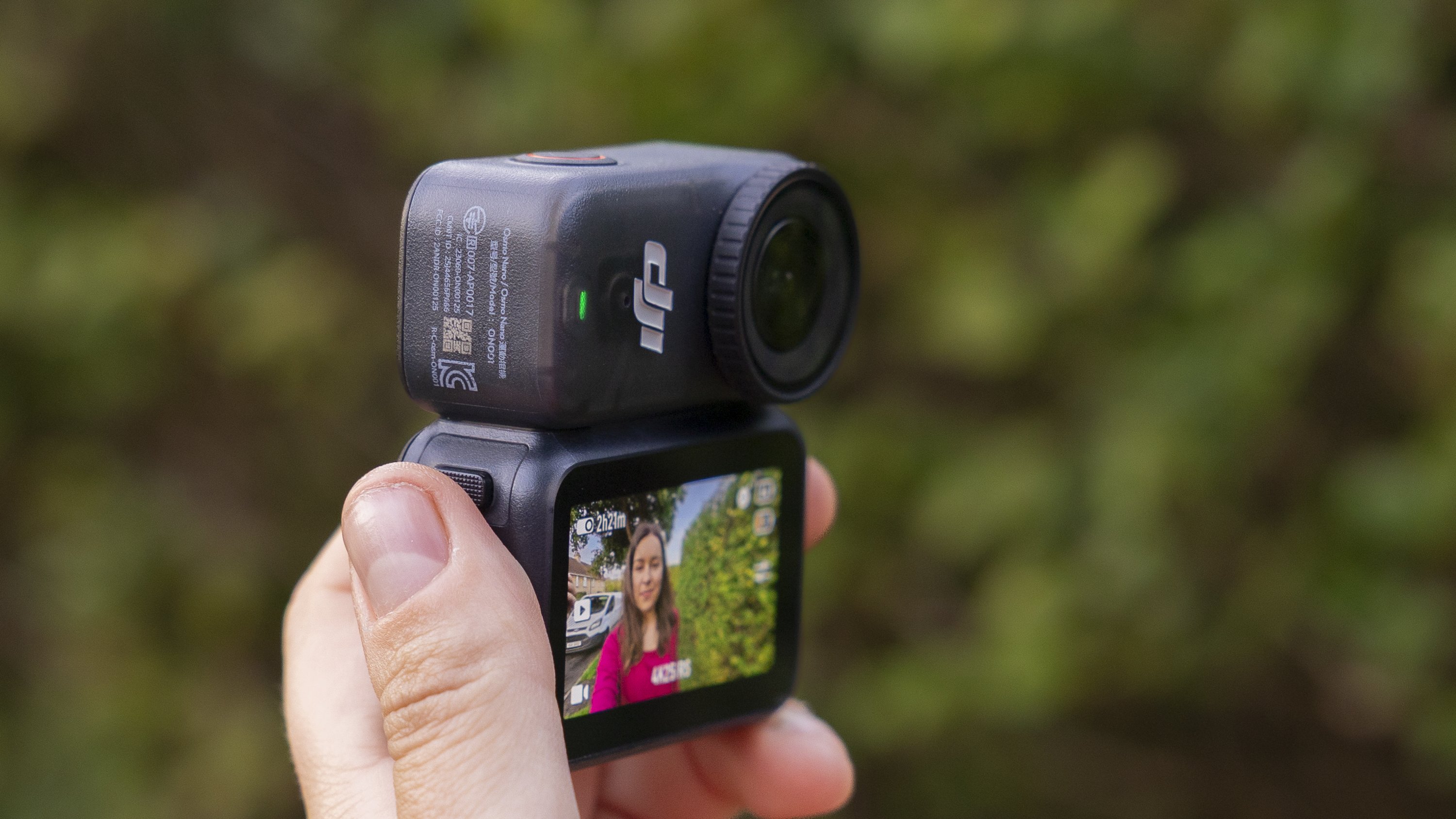 The DJI Osmo Nano held by a female photographer in a pink top