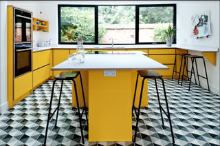 yellow kitchen cabinets with patterned flooring and yellow kitchen island