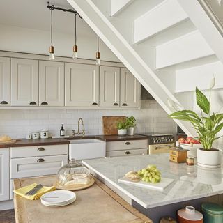 White kitchen with counter under the staircase