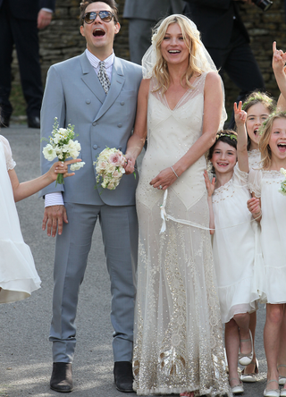 Kate Moss and Jamie Hince pose outside the church after getting married in 2011 in Southrop, England