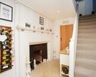 hallway area with fireplace and white wall