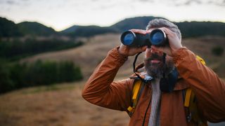Man using binoculars in the hills