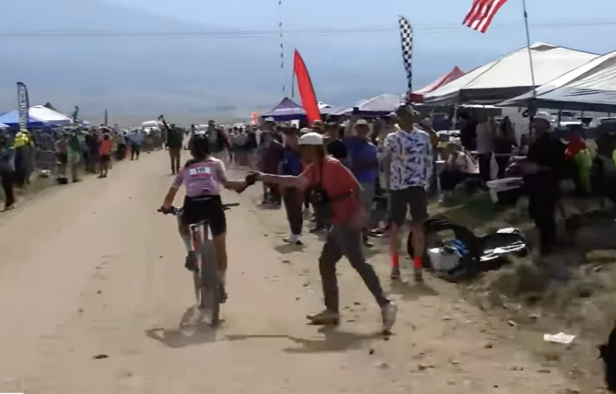 Lauren Stephens passes through an approved feed zone area for all riders at 2025 Leadville Trail 100 MTB, and will drop the handoff shown on live broadcast from Life Time