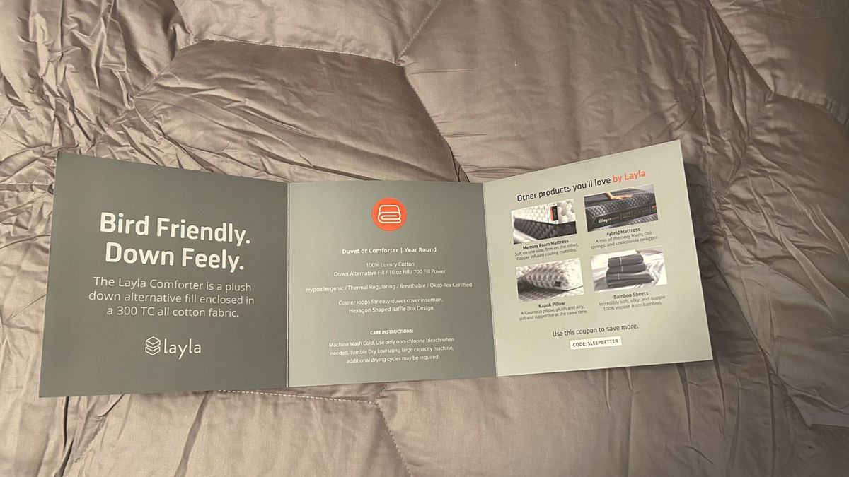 The image shows an information pamphlet on top of the Layla Down Alternative Comforter