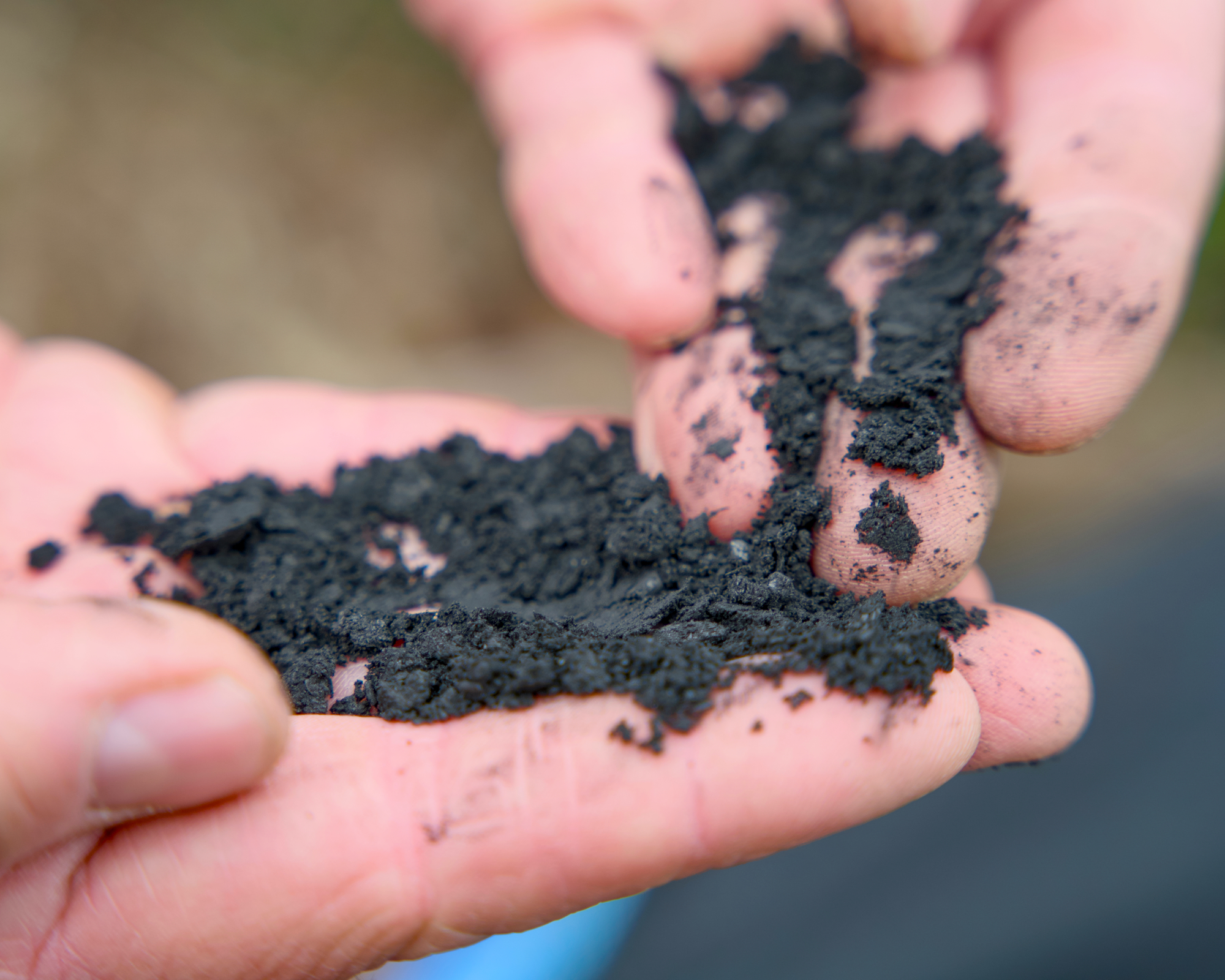 hands holding biochar