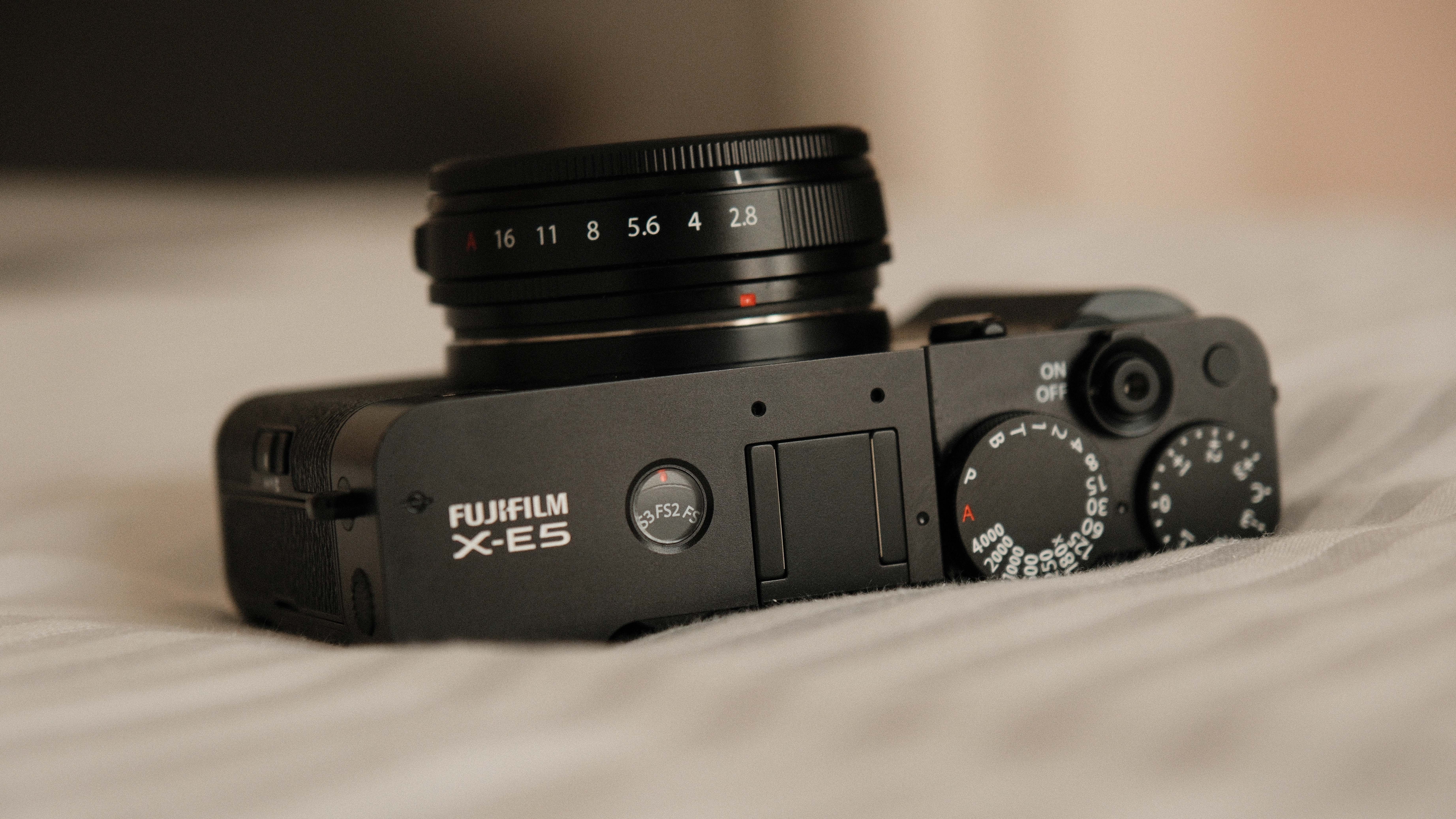 Fujifilm X-E5 camera with a 23mm f/2.8 R WR lens attached on a white bedspread