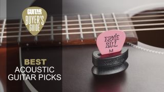 An Ernie Ball guitar pick in a pick buddy on top of an acoustic guitar