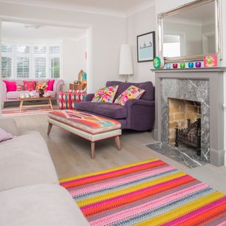 A large bright living room with colourful rugs and sofas