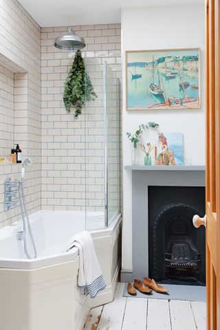 white and cream bathroom with blue grout and metro tiles and fireplace