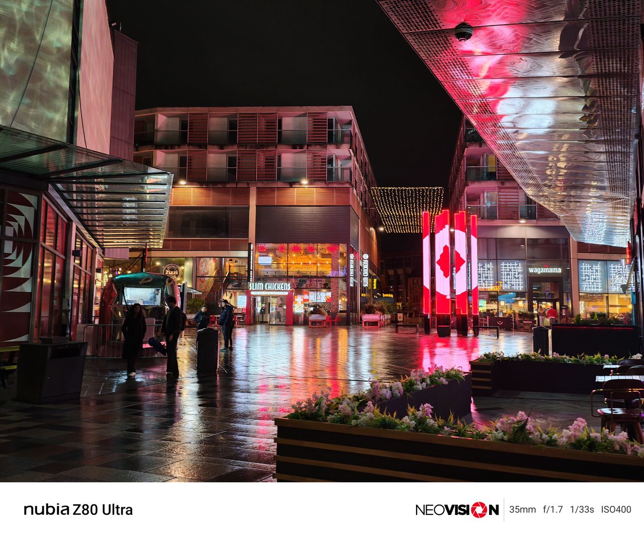 City shopping centre lit up at night with colorful lights