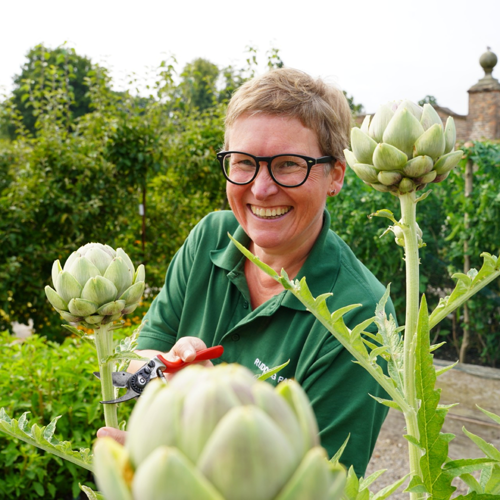 female with short hair and glasses pruning plants