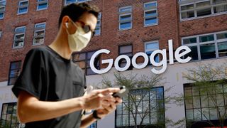 A man checks his phone near a Google Corporate Office on April 13, 2021 in New York