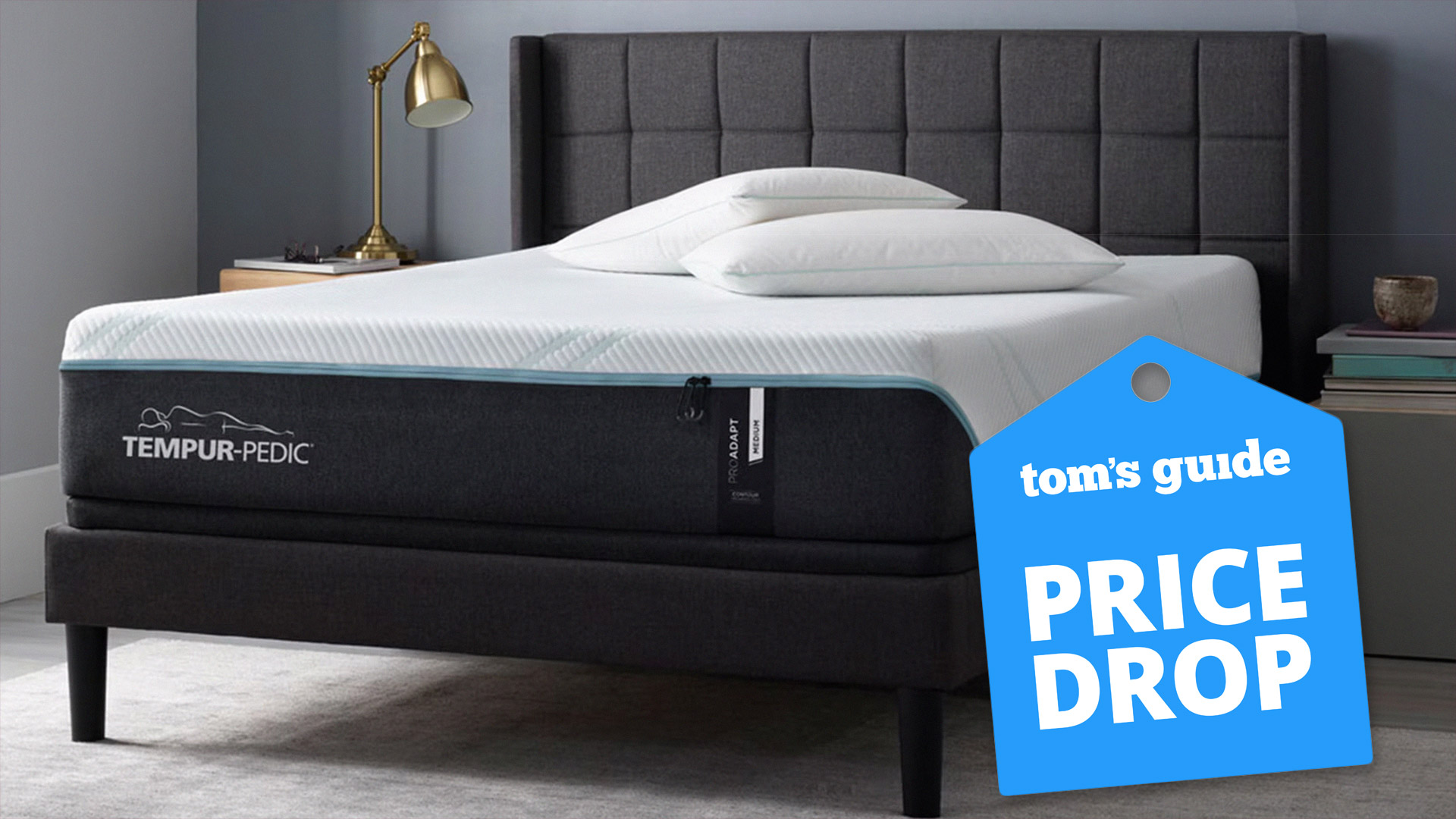Tempur-Pedic Tempur-ProAdapt mattress in a grey bedroom, with a Tom's Guide badge overlaid saying "PRICE DROP"