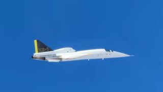 a white aircraft flies under blue skies