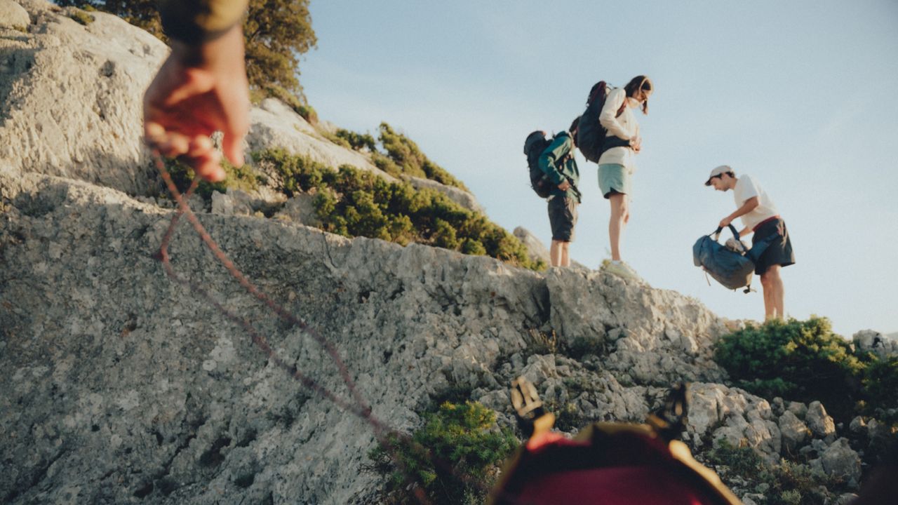 Group of hikers setting up camp on the mountainside