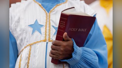 A congregant holds the King James Bible during a church service in South London in 2013.