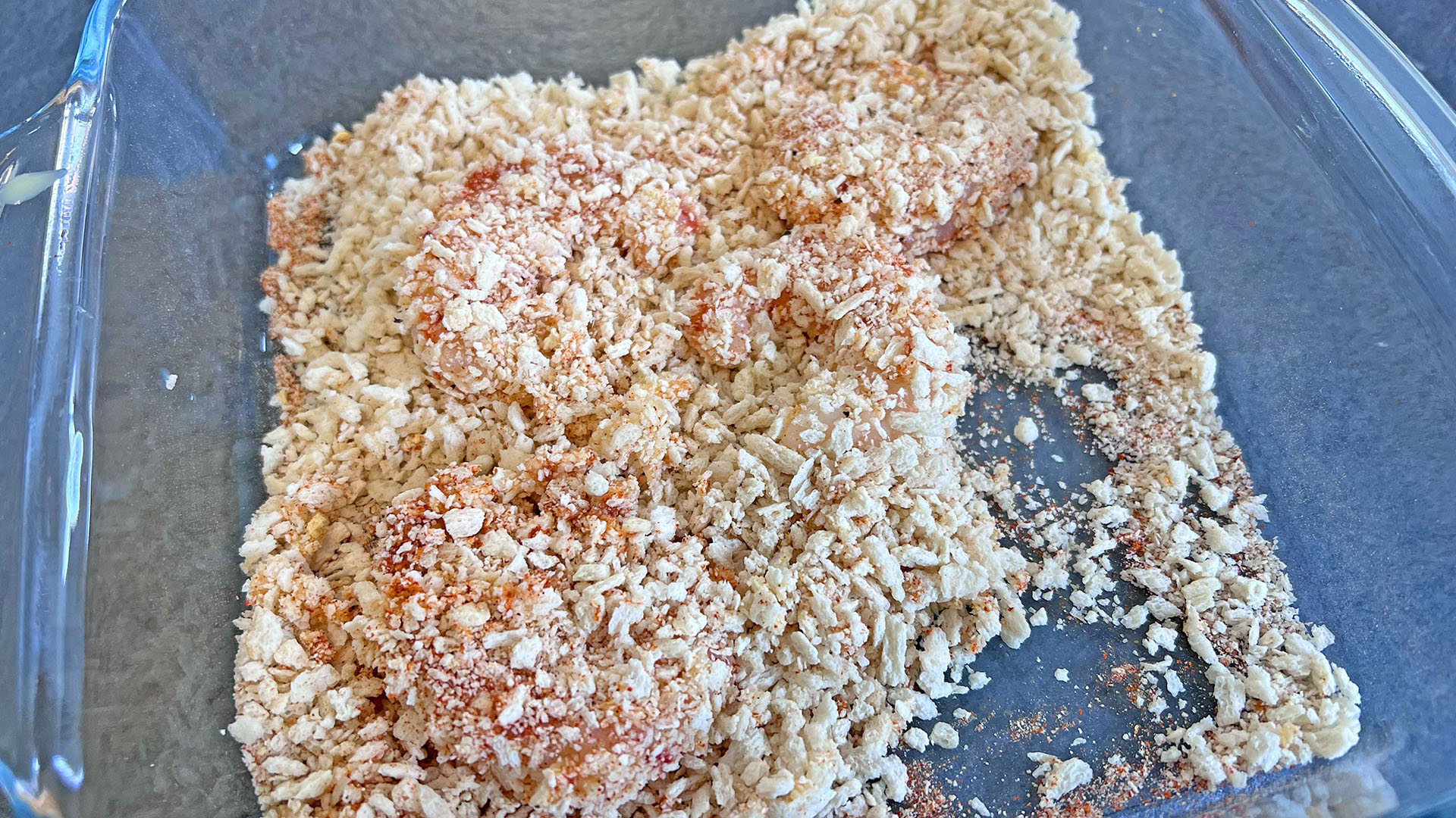 Raw shrimp being rolled in crispy coating
