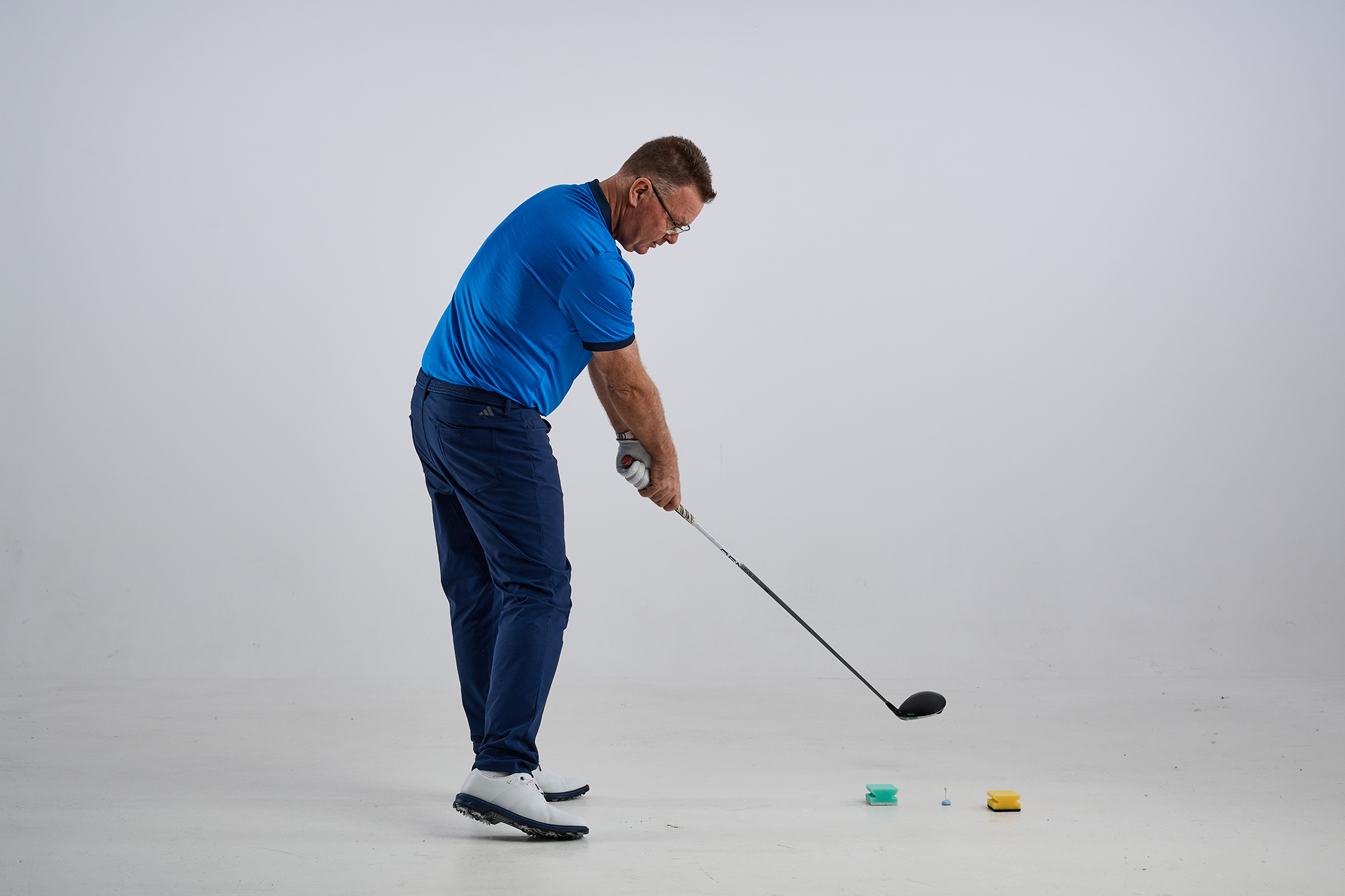 John Jacobs demonstrating a good exit position after hitting the golf ball, avoiding the sponges that form the gate and therefore neutralizing a slice