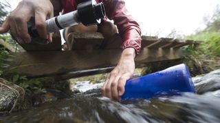 how to choose a water purifier: hiker ready to use a filtration system