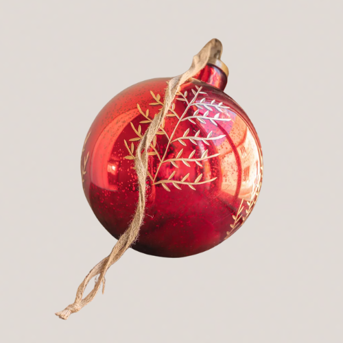 A large red bauble with foliage etched onto it