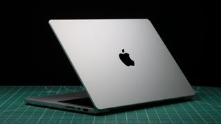 MacBook Pro 14 pouces (2023) dans un studio avec le couvercle partiellement fermé montrant le logo Apple