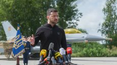 Ukraine's President Volodymyr Zelenskyy stands in front of the first General Dynamics F-16 Fighting Falcon received by Ukraine as he congratulates Ukrainian military on the Day of Ukrainian Air Force on 4 August 2024