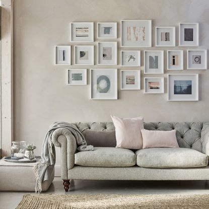 Grey sofa below picture gallery on wall