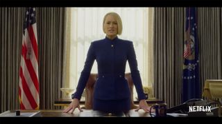 Screenshot of Netflix show House of Cards, with main character Claire Underwood stood at Resolute desk, backlit