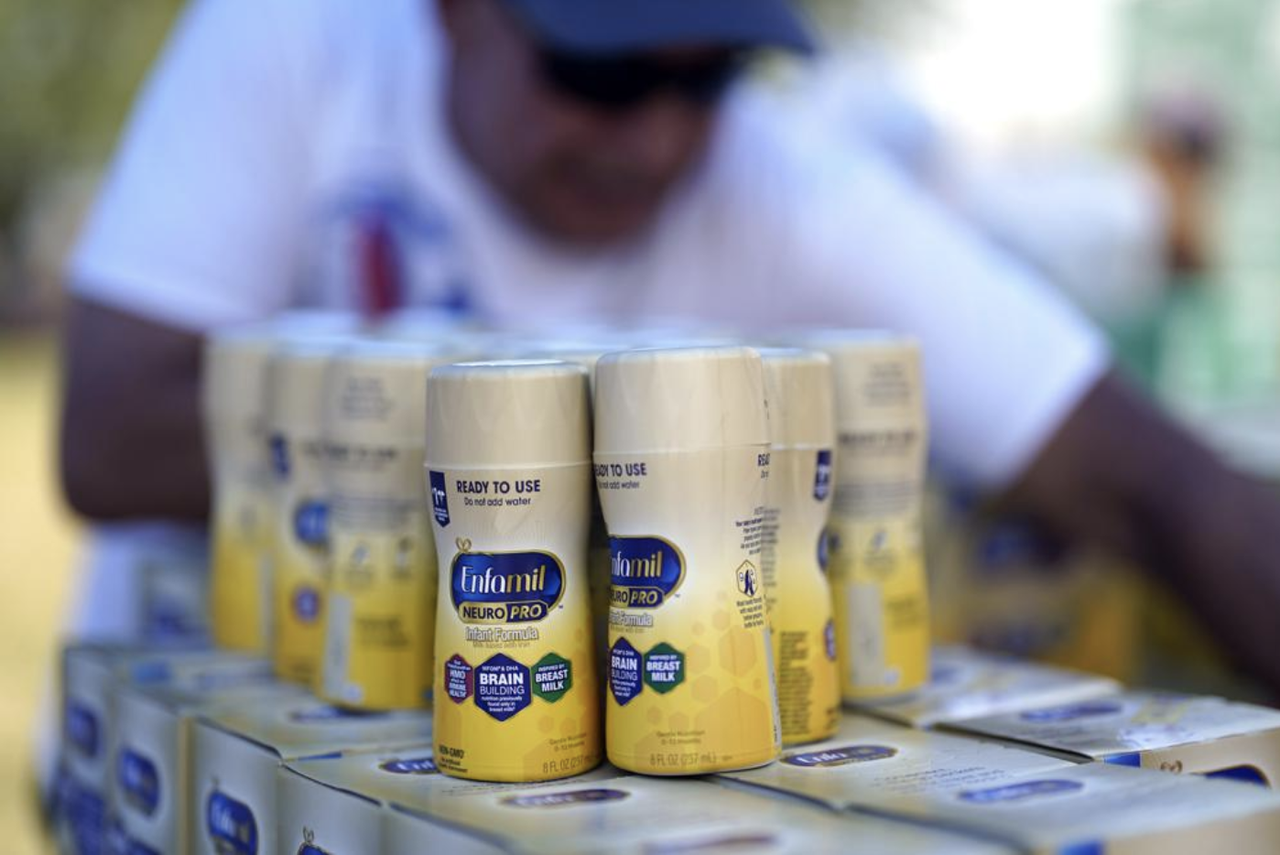 Infant formula is stacked on a table during a baby formula drive to help with the shortage.