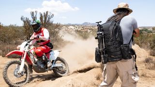 Lowepro ProTactic BP 450 AW II backpack worn by a person standing in a dirt biking rally