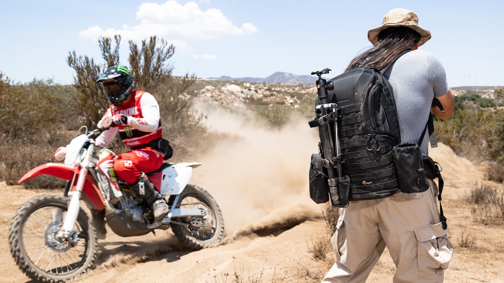 Lowepro ProTactic BP 450 AW II backpack worn by a person standing in a dirt biking rally