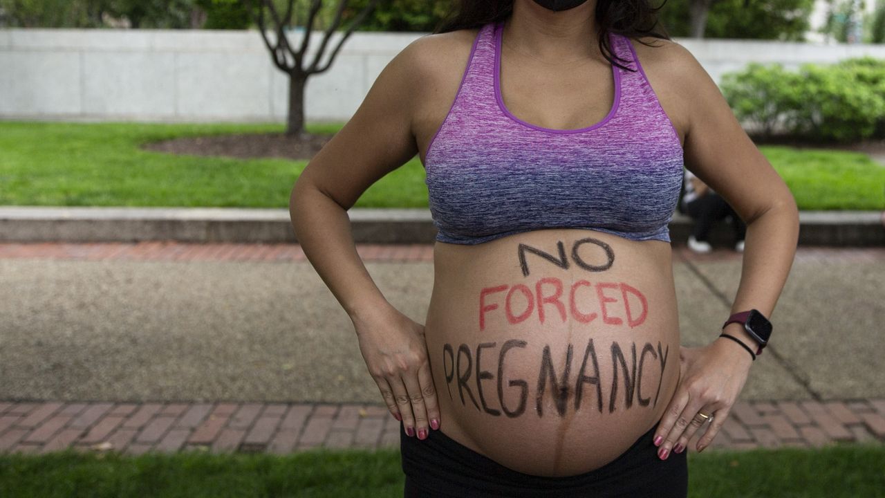 Pregnant woman with &quot;no forced pregnancy&quot; written on her belly