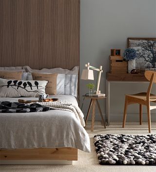 grey bedroom with wood veneer bed and wooden furniture