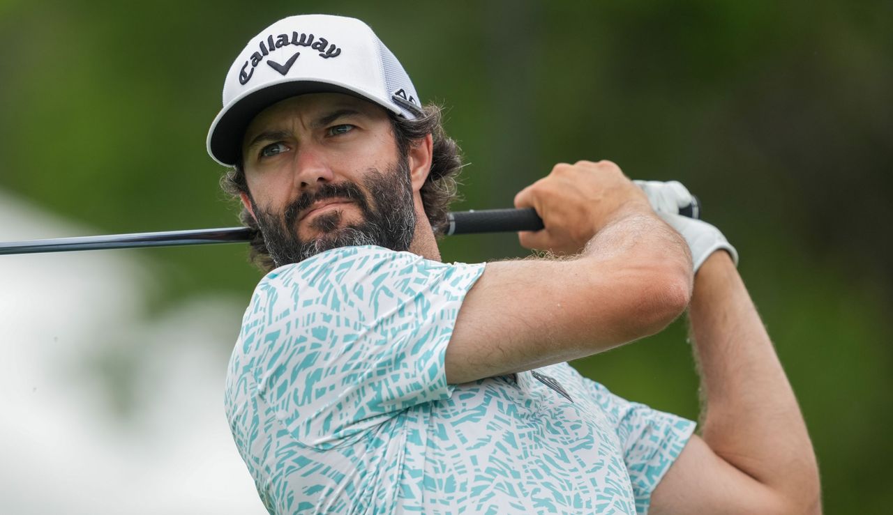 Adam Hadwin hits his tee shot and watches the ball flight