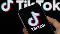 TikTok logo on a phone in front of TikTok logo