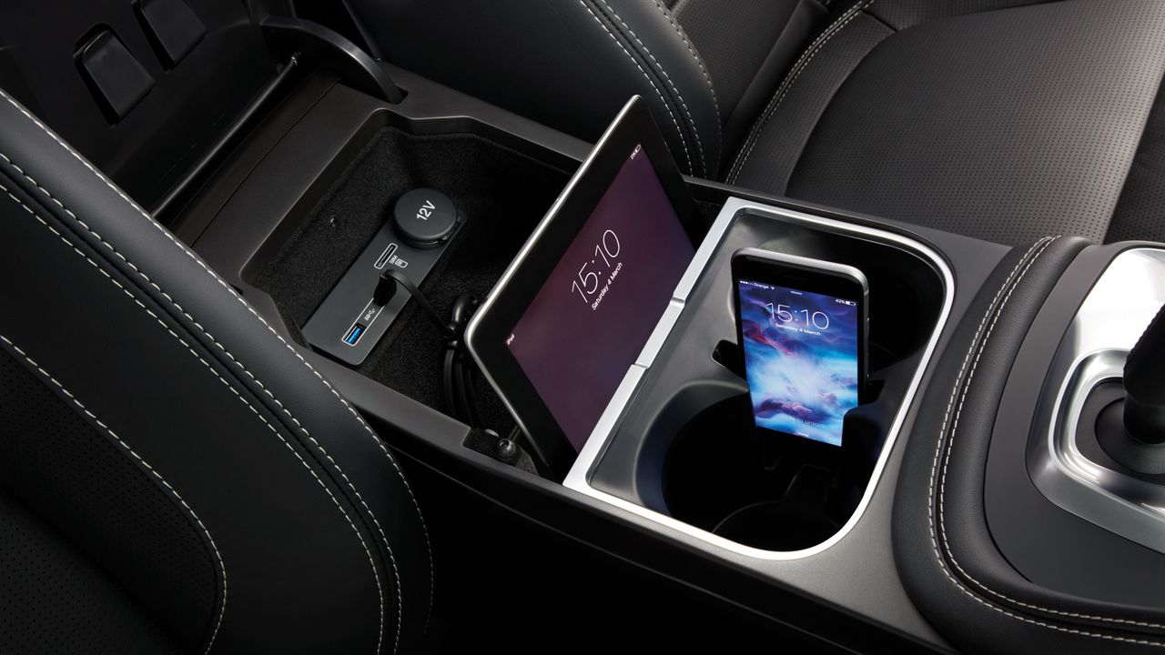 The storage bin between the front seats provides two USB ports and holders for your phone and tablet