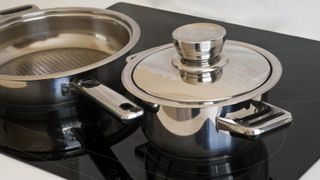 Stainless steel cookware on a glass stove top