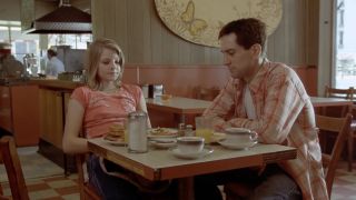 Robert De Niro and Jodie Foster seated at diner table eating breakfast in Taxi Driver