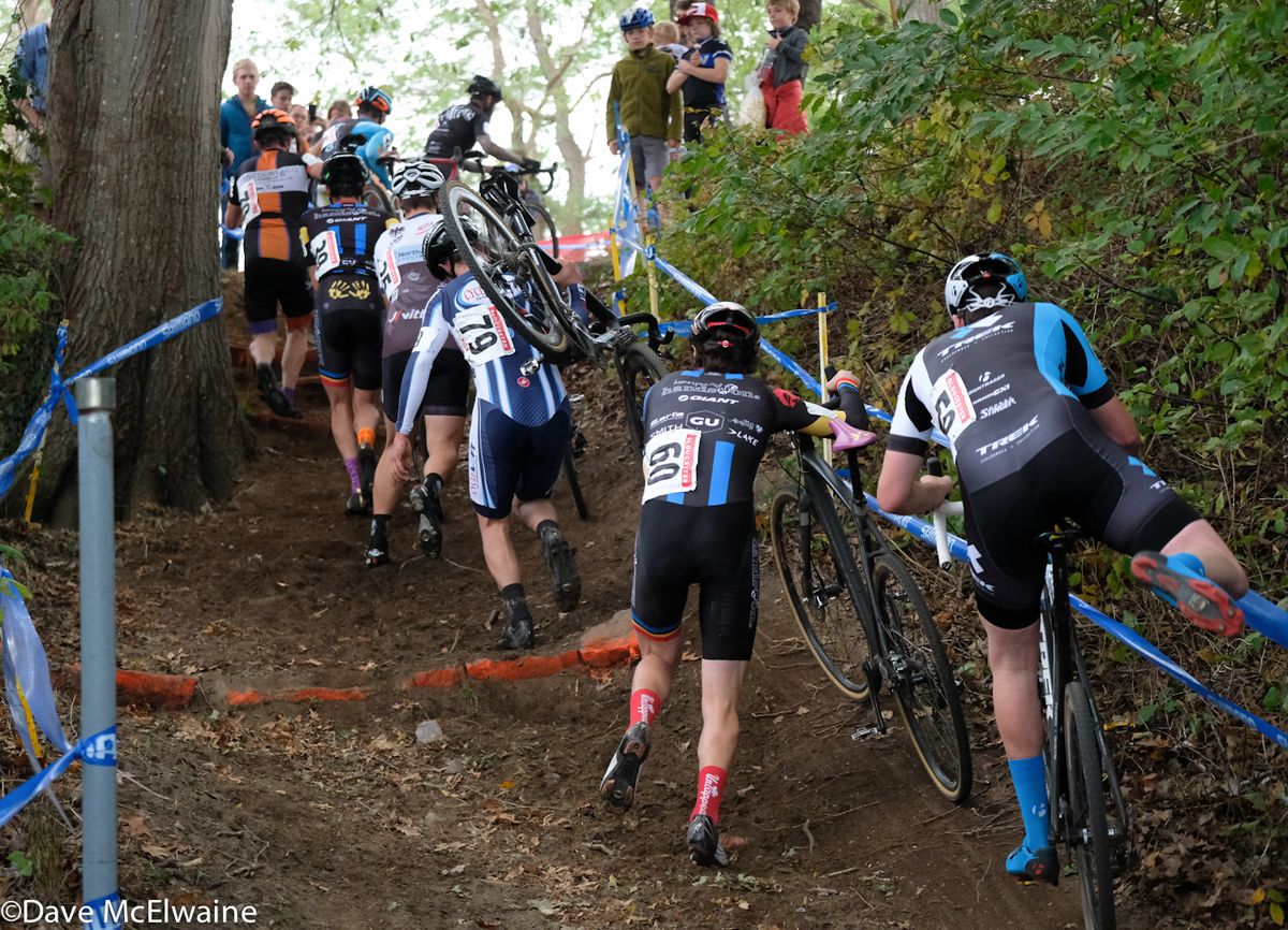 A group of racers towards the back of the pack dismount for the new run-up