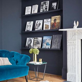 Dark grey living room with picture rails and blue sofa