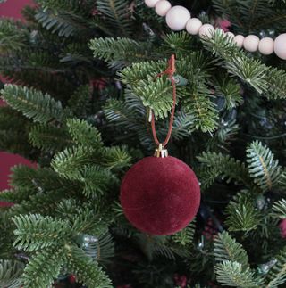 close up of a red ornament on a christmas tree