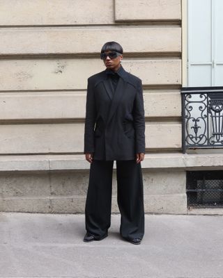 An influencer wears a black pantsuit.