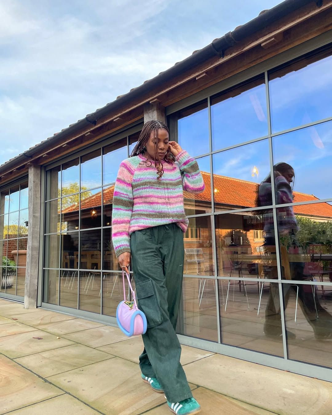 Oluwaseun in Sezane stripey jumper, green cargo trouusers, and Adidas Gazelles
